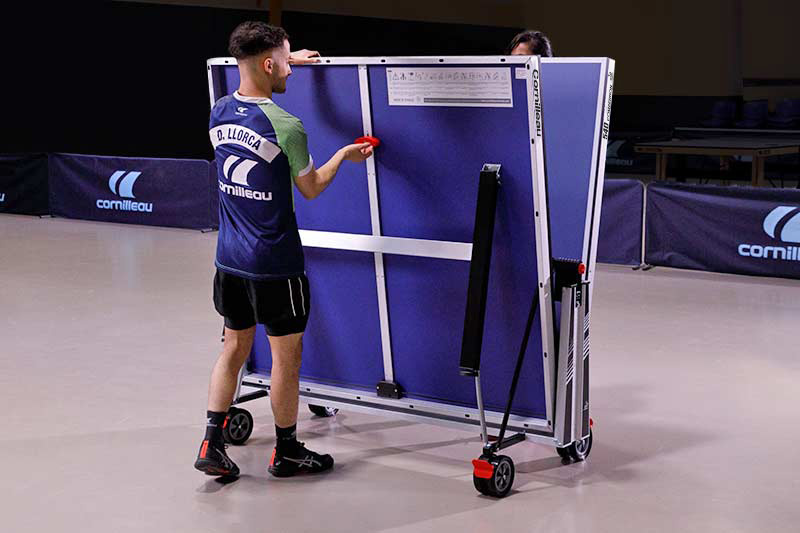 People folding a Cornilleau Competition 540 ITTF table tennis table